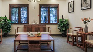 Un comedor tradicional con una mesa y sillas de madera, plantas en macetas y obras de arte enmarcadas en las paredes.
