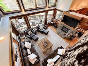 A spacious living area with a fireplace, leather sofas, and a large TV.