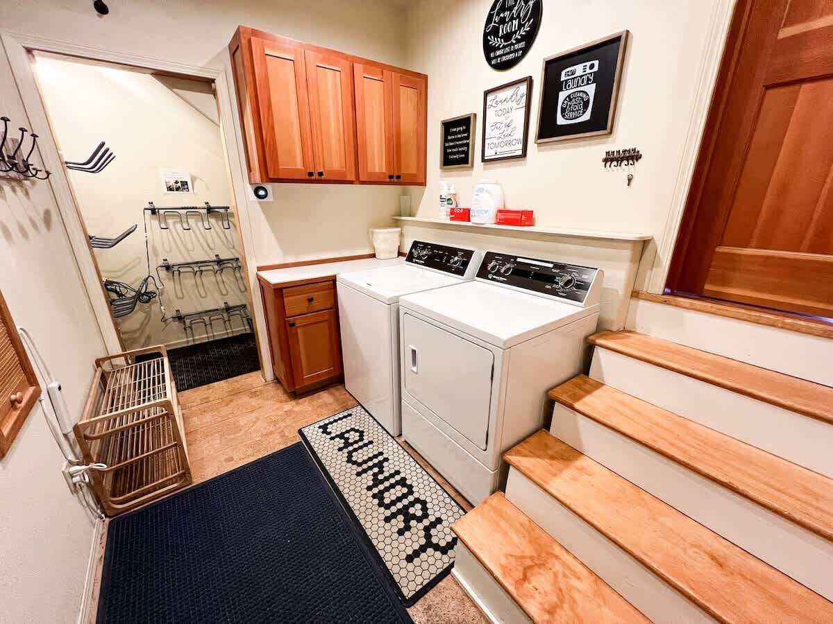 A laundry area with a washing machine, dryer, and a small cabinet.