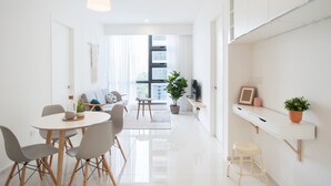 Ein modernes, helles Wohnzimmer mit Essbereich, großem Fenster und minimalistischem Design.