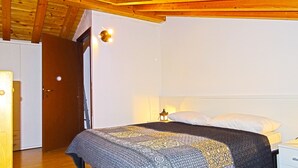 A bedroom with a bed, a nightstand, a lamp, and a wooden ceiling. - La Quiete 56 Holideal (Tremosine)
