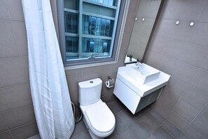 A modern bathroom with a toilet, sink, and window. - S1 Awesome 1BR near KLCC - KL Tower - Hi Speed WIFI (Kuala Lumpur)