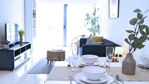 A modern living room with a dining area set for a meal. - S1 Awesome 1BR near KLCC - KL Tower - Hi Speed WIFI (Kuala Lumpur)
