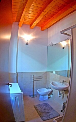 A bathroom with a wooden ceiling, a white sink, a bidet, and a towel rack. - La Quiete 58 Holideal (Tremosine)