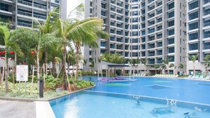 A swimming pool with lounge chairs and palm trees, surrounded by high-rise buildings. - A3 FAMILY Suites 4-6pax Jonker Melaka (Malacca City)