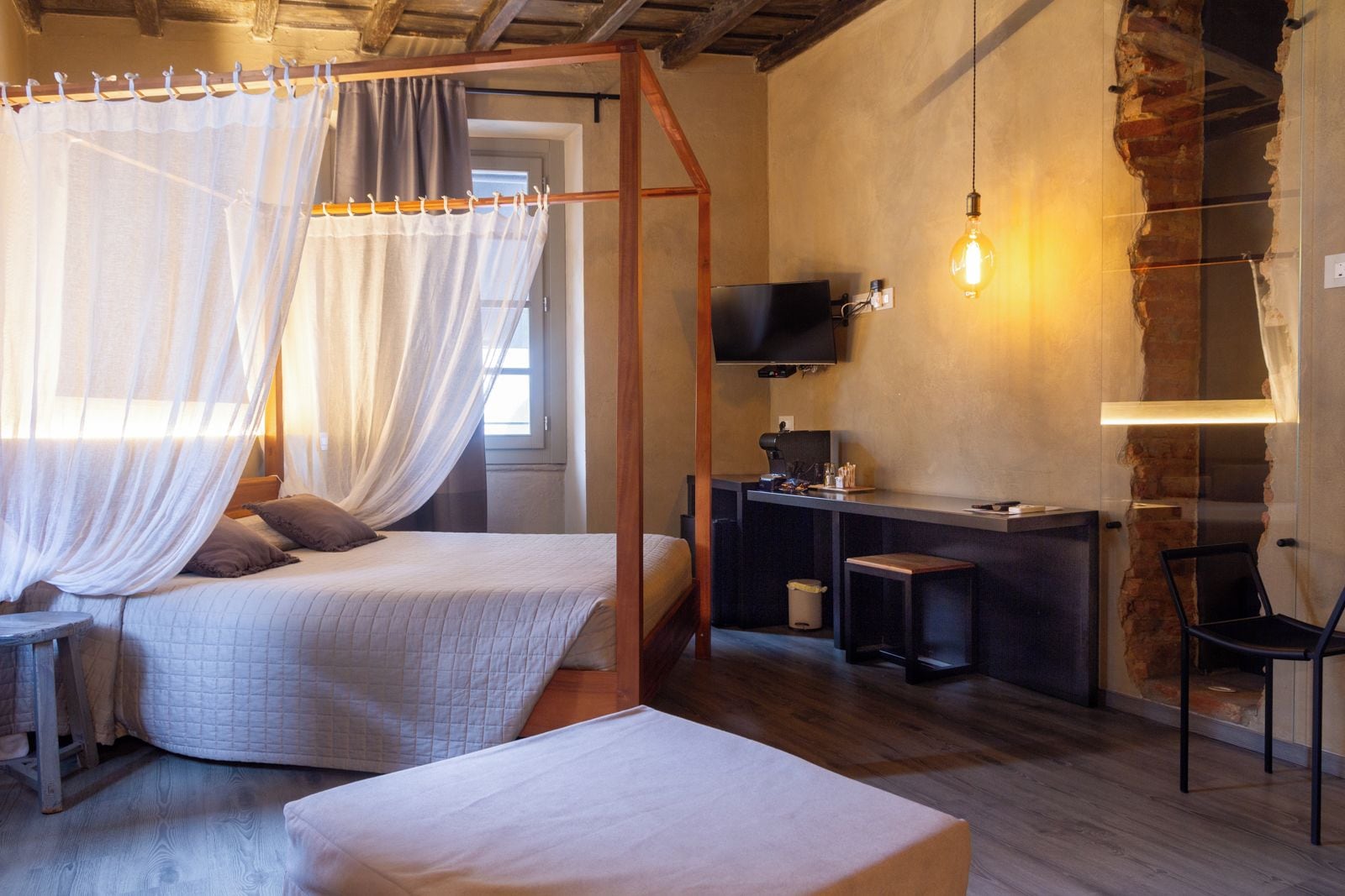 A bedroom with a bed, a desk, a chair, and a television.