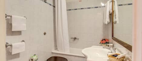 A bathroom with a toilet, sink, and shower.