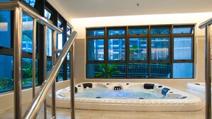 A large indoor hot tub with a view of a balcony and plants. - Atlantis Residence by Stayshare Homes (Malacca City)