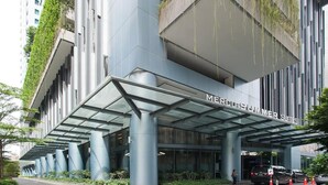Ein modernes Gebäude mit einem großen Glasanbau, auf dem "MERCURYSUMMER SUITES" steht.