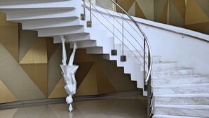 Eine moderne Treppe mit geometrischer Wandgestaltung und einem Metallgeländer.
