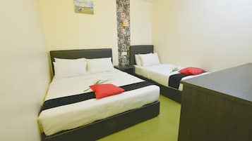 A hotel room with two beds, a desk, and a patterned wall.