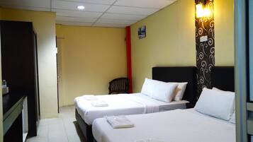 Une chambre d’hôtel avec deux lits, un bureau et une chaise.