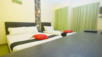 Habitación de hotel con dos camas, un escritorio y una cortina verde.