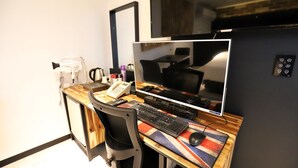 Un espacio de trabajo moderno con escritorio, computadora, teclado, ratón y teléfono.