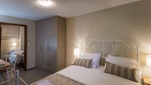 Ein Schlafzimmer mit einem Bett, Nachttischlampen, einem Schreibtisch und einem Kleiderschrank.