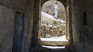 Ein rundbogiges Portal, das zu einer Steintreppe führt.