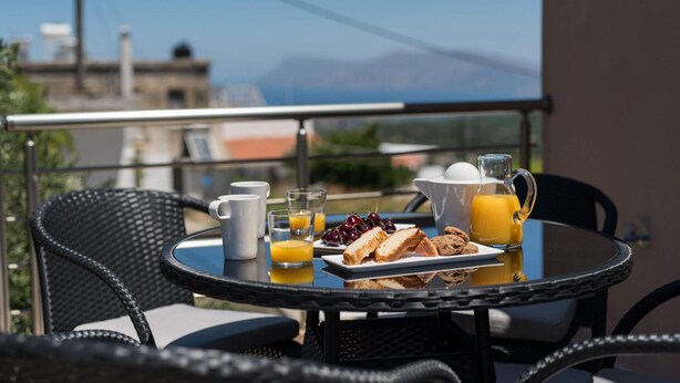 Ein Frühstückstisch mit Blick auf Berge und eine Stadtlandschaft.