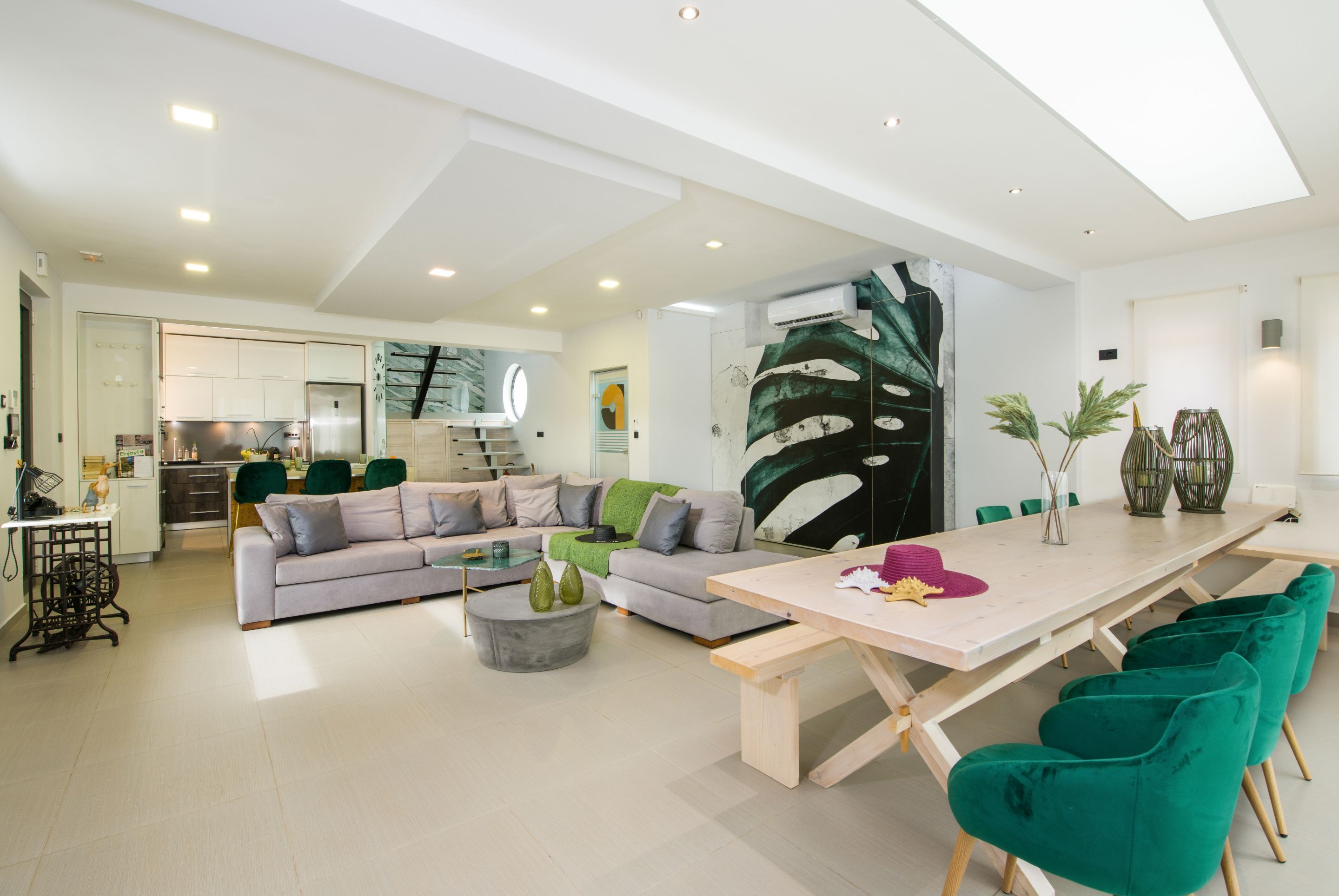 En moderne stue med sofa, sofabord og spiseplads.