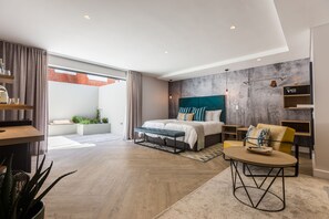 A modern bedroom with a large bed, a desk, and a view of the outside. - The Junction Boutique Hotel (Plettenberg Bay)