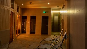 Passadís amb armaris de fusta, una porta de vidre i una zona de dutxes.
