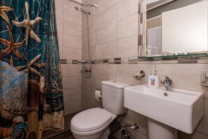 Ein Badezimmer mit Toilette, Waschbecken und Dusche.