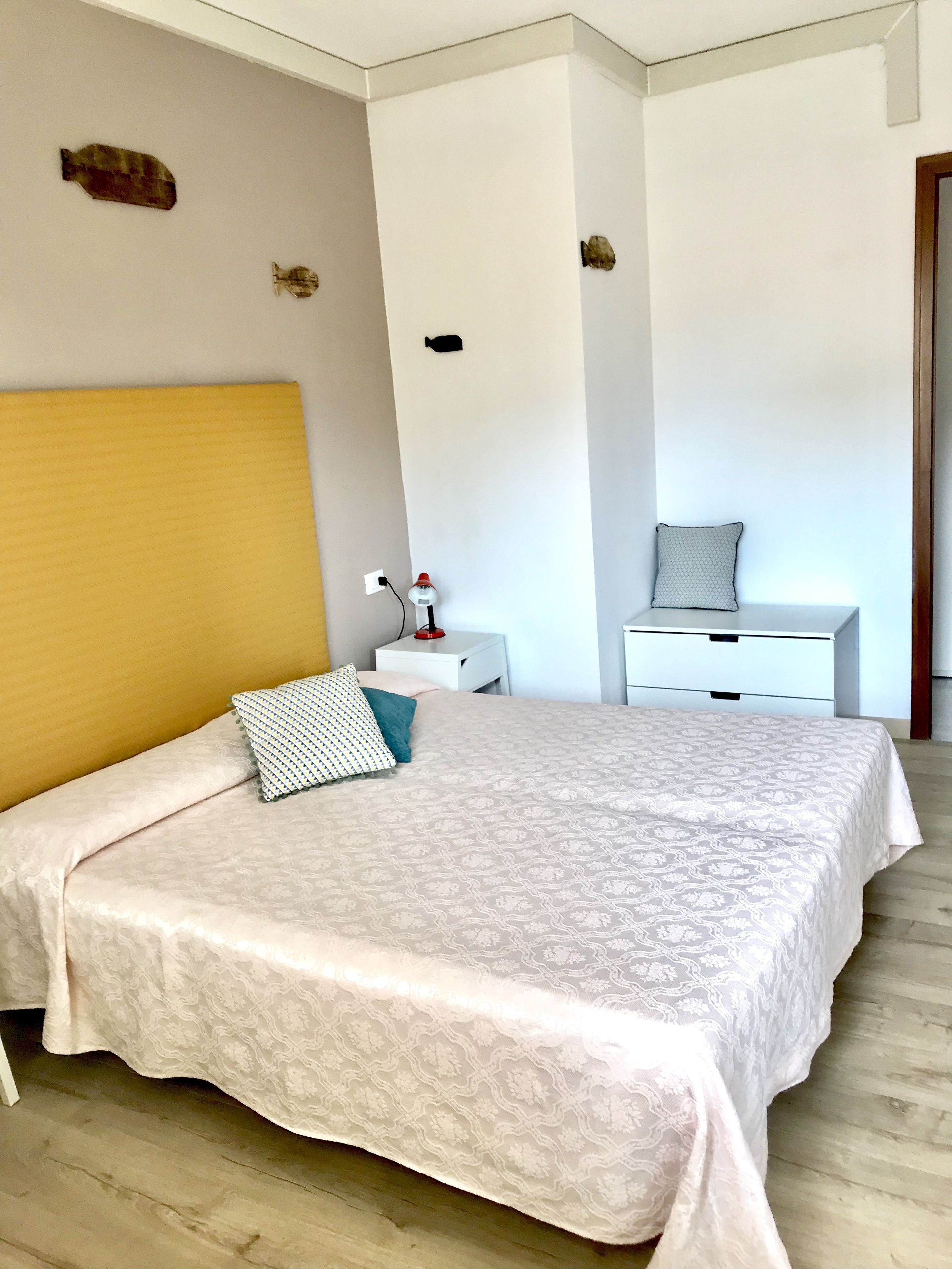 A modern bedroom with a large bed, a bedside table, and a nightstand.