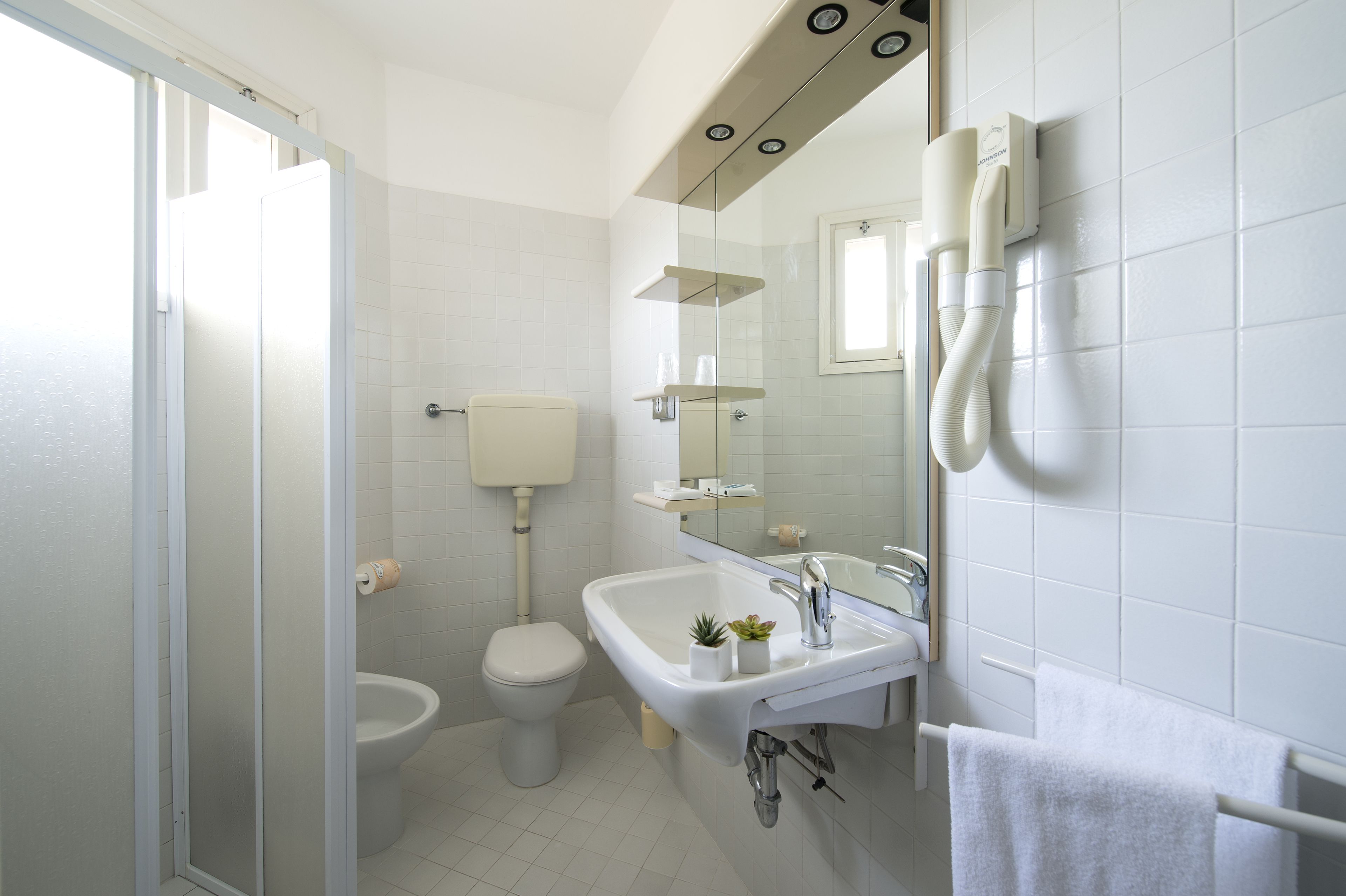 Un baño moderno con inodoro, lavamanos y ducha.