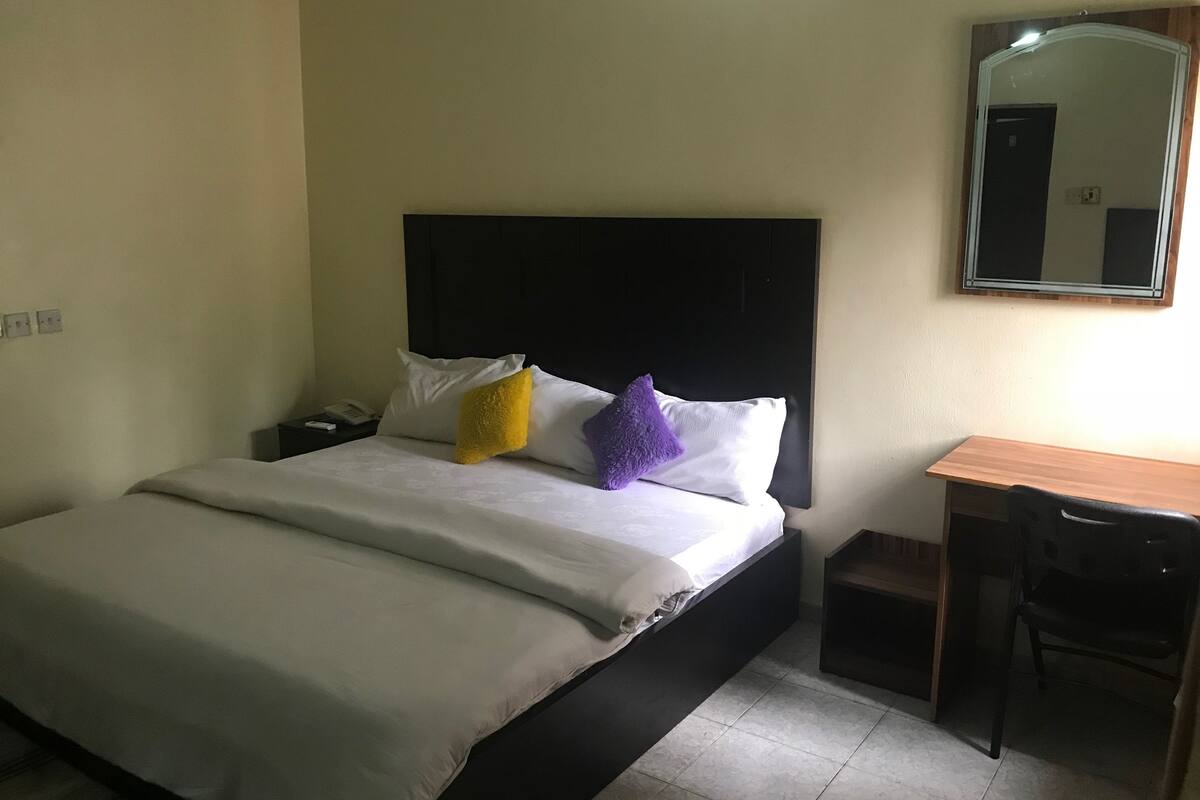 Ein Hotelzimmer mit einem Bett, einem Schreibtisch und einem Stuhl.