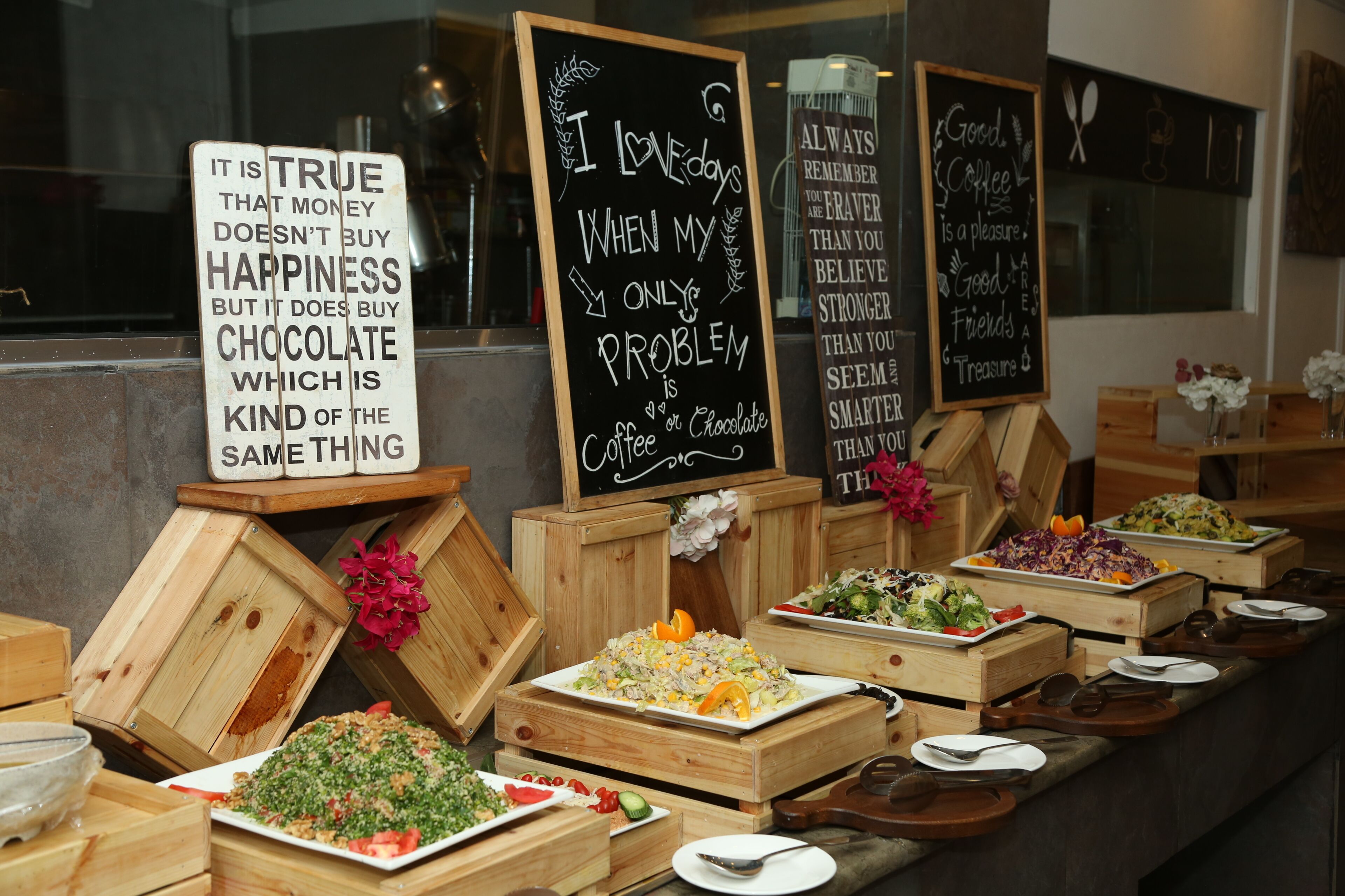 A buffet with various dishes and a sign with a humorous message.