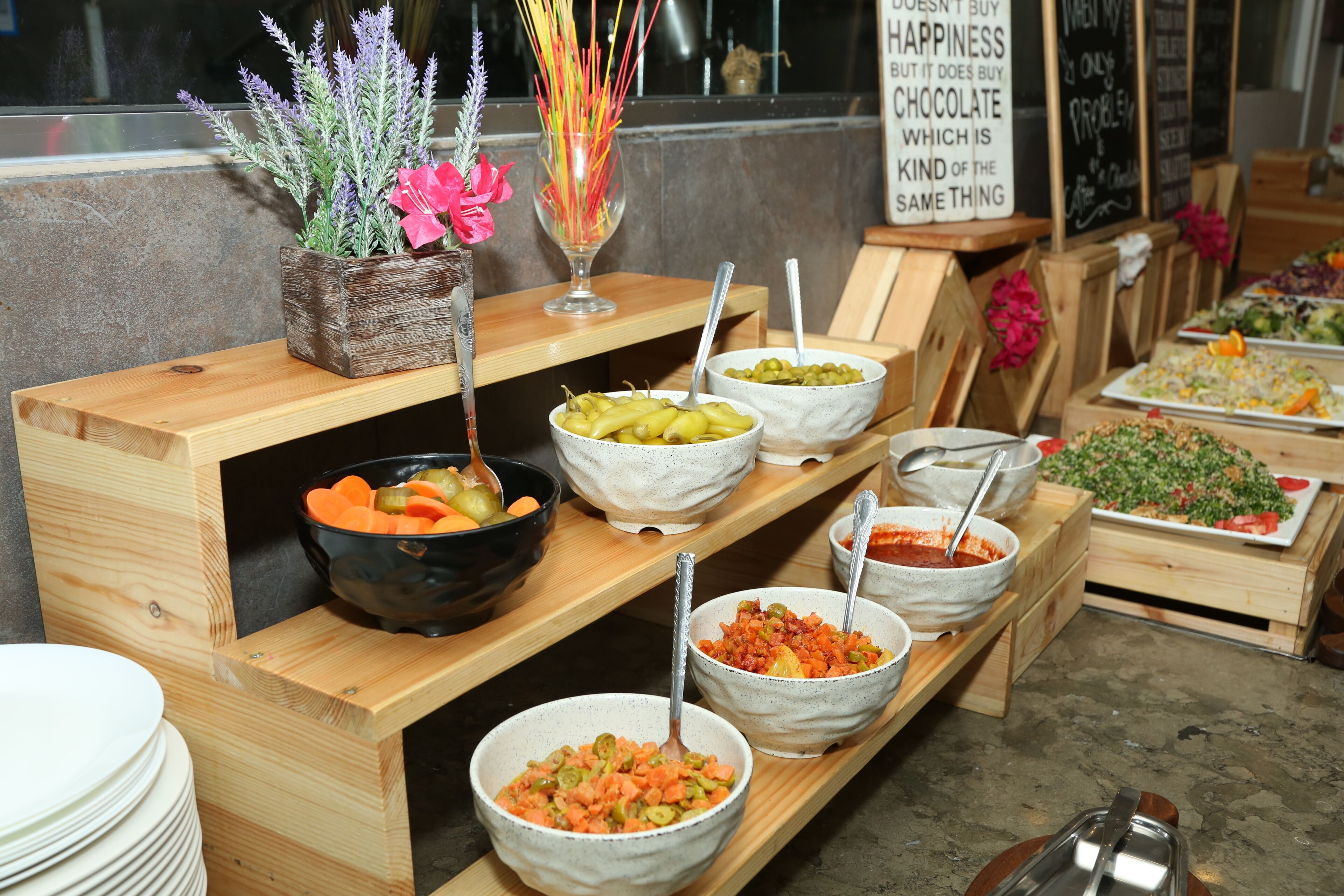 A buffet setup with various food bowls and a sign with a quote.
