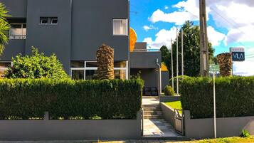 Un hôtel moderne avec un pilier en pierre, un ciel dégagé et une enseigne indiquant la rue Vila Maritas.
