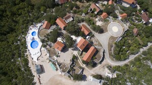 Eine Vogelperspektive auf eine Wohngegend mit mehreren Häusern, einer kreisförmigen Einfahrt und einem Schwimmbadkomplex.