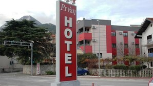 Ein Hotelschild mit dem Schriftzug "Prvan HOTEL" und einem Berg im Hintergrund.