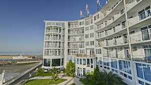 Un hôtel à plusieurs étages doté de balcons, de grandes fenêtres et offrant une vue sur la mer.