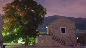 Un bâtiment en pierre avec une petite fenêtre et un escalier menant à l’étage supérieur.