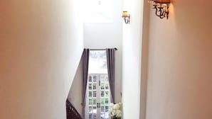 A staircase leading to a door with a view of greenery outside. - Cochi Villa Hoi An (Da Nang)