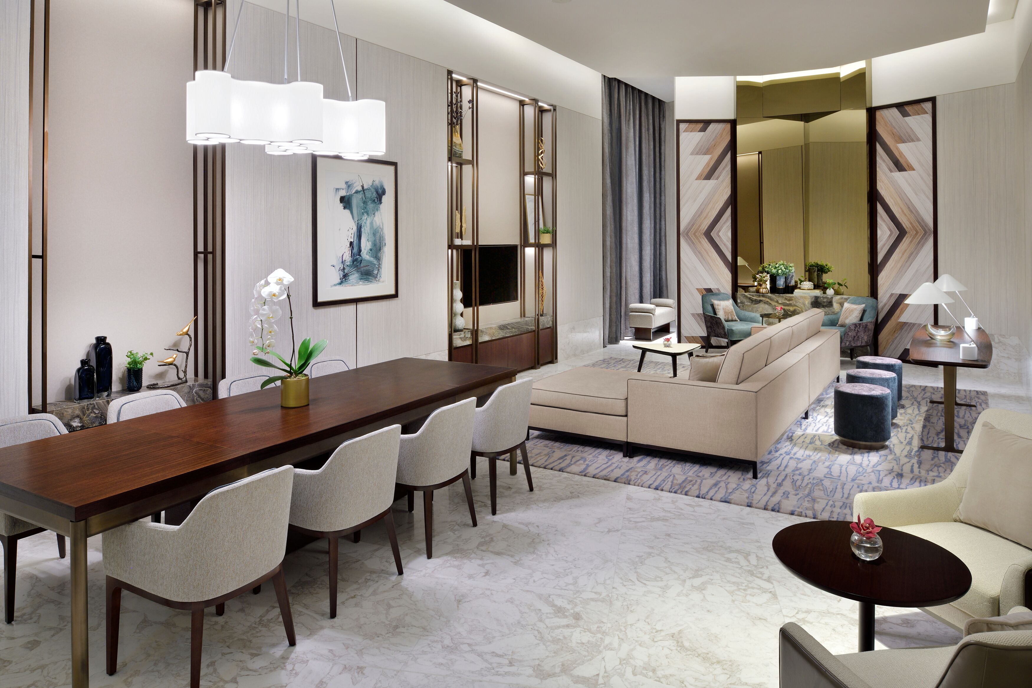 A modern hotel room with a dining area, a sofa, and a coffee table.