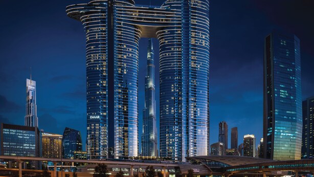 A modern high-rise building with a distinctive curved top and a central atrium.