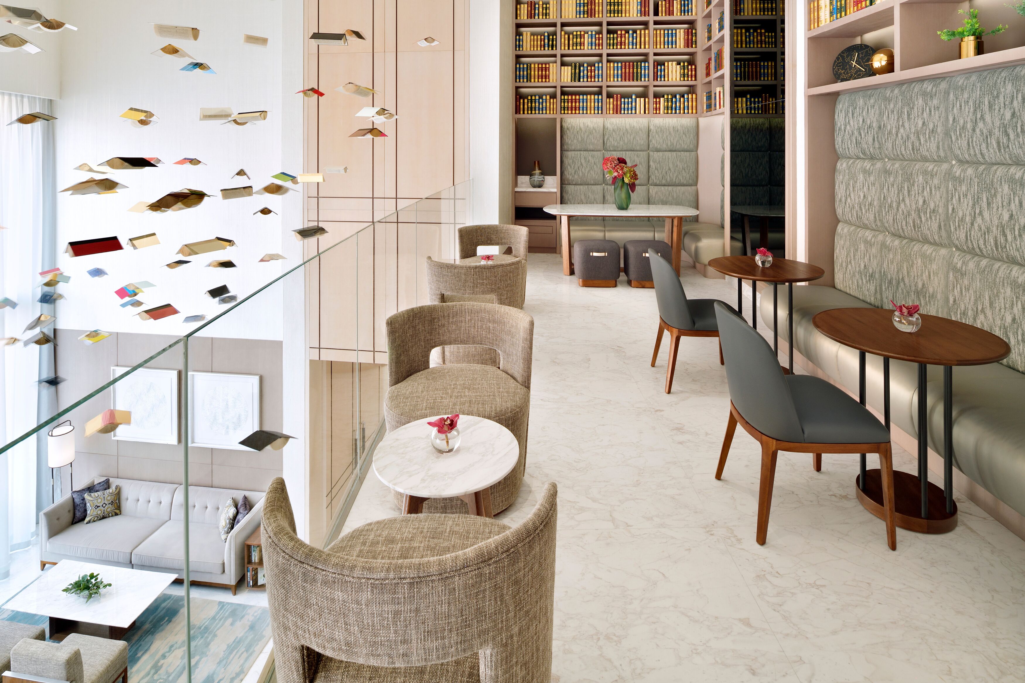 Un intérieur moderne avec un escalier, un coin salon et une bibliothèque.