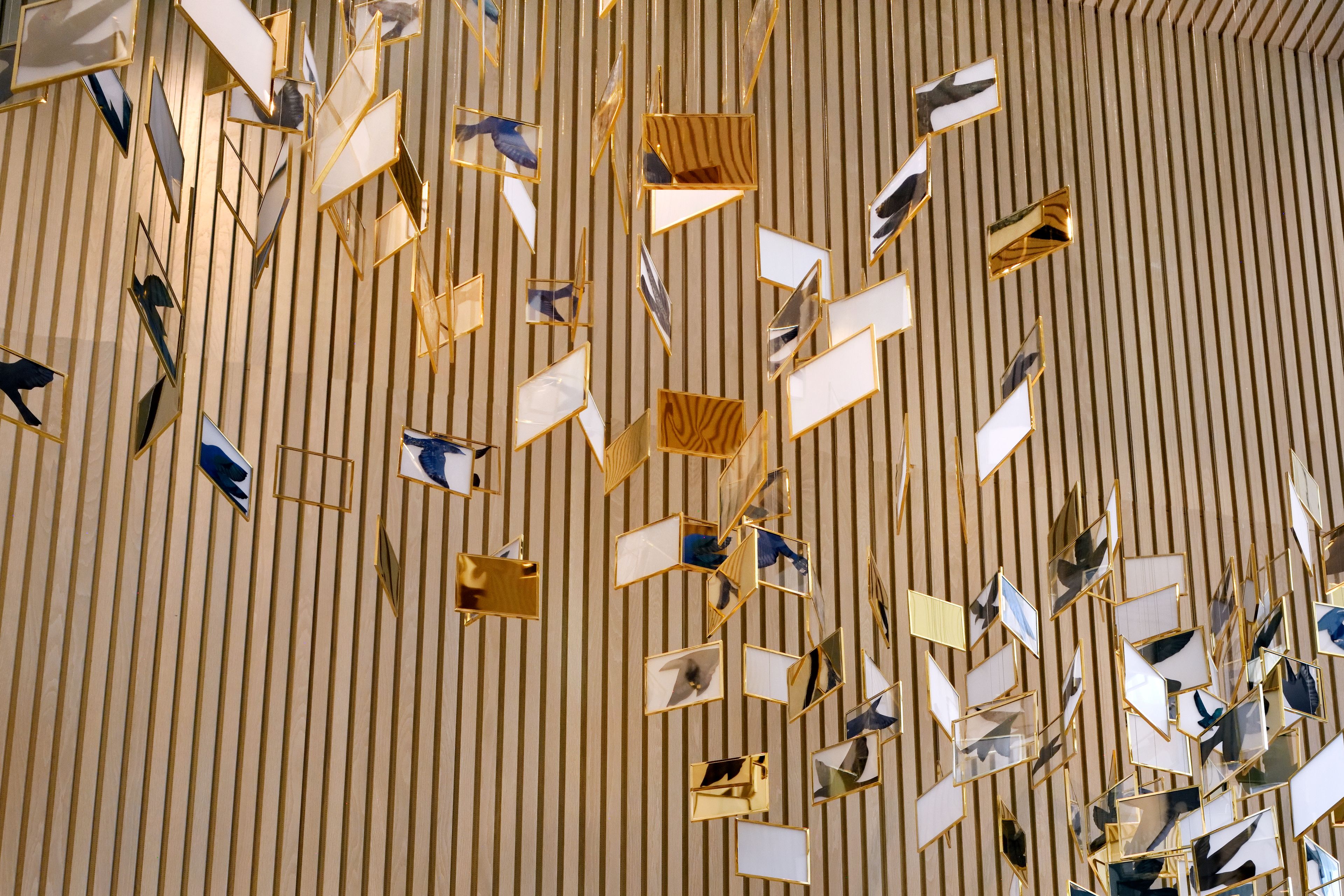Un plafond composé de panneaux réfléchissants disposés selon un motif géométrique.