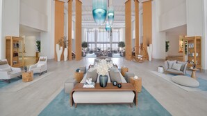 A spacious lobby with a central seating area, large windows, and modern decor. - Vida Creek Harbour (Dubai)