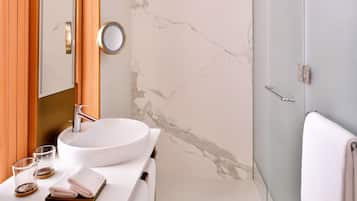 Une salle de bain avec un lavabo blanc, un miroir et un porte-serviettes.