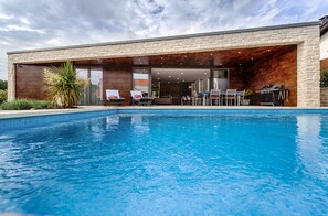 Piscine extérieure, parasols de plage, chaises longues