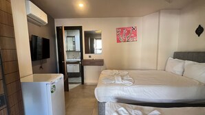 A hotel room with two beds, a refrigerator, a TV, a mirror, and a bathroom visible through an open door. - Hayal Residence Apart Otel (Antalya)