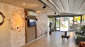 A spacious lobby with a piano, sofas, and a TV screen. - Hayal Residence Apart Otel (Antalya)