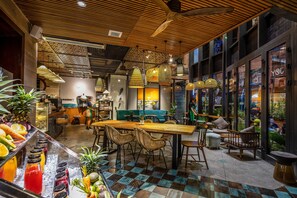 A modern cafe with a wooden ceiling, checkered floor, and a variety of seating options including tables and chairs. - Seahorse Han Market Da Nang Hostel by Haviland (Da Nang)