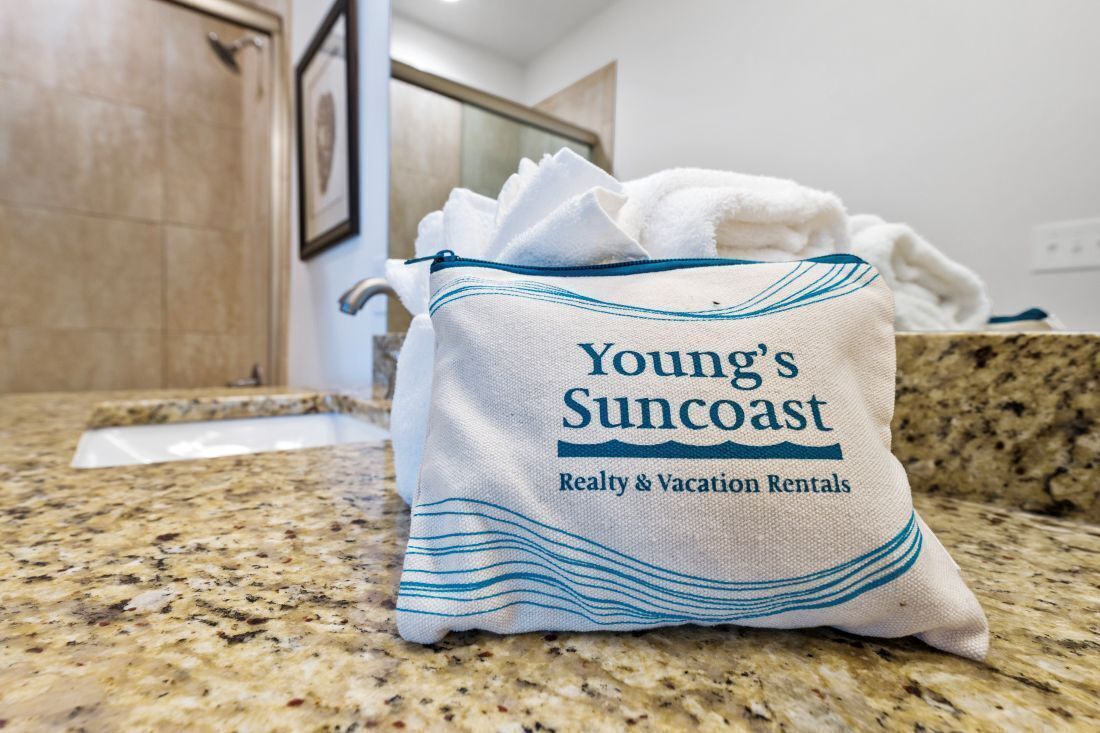 A bag labeled "Young's Suncoast Realty & Vacation Rentals" on a granite countertop.