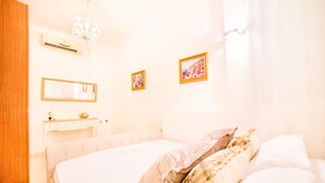 Une chambre à coucher avec un lit, une commode, un miroir et deux tableaux encadrés accrochés au mur.