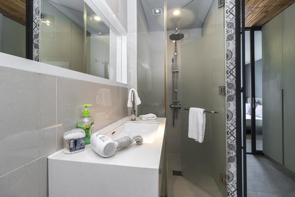 A modern bathroom with a glass-enclosed shower, a white sink, and a mirror.