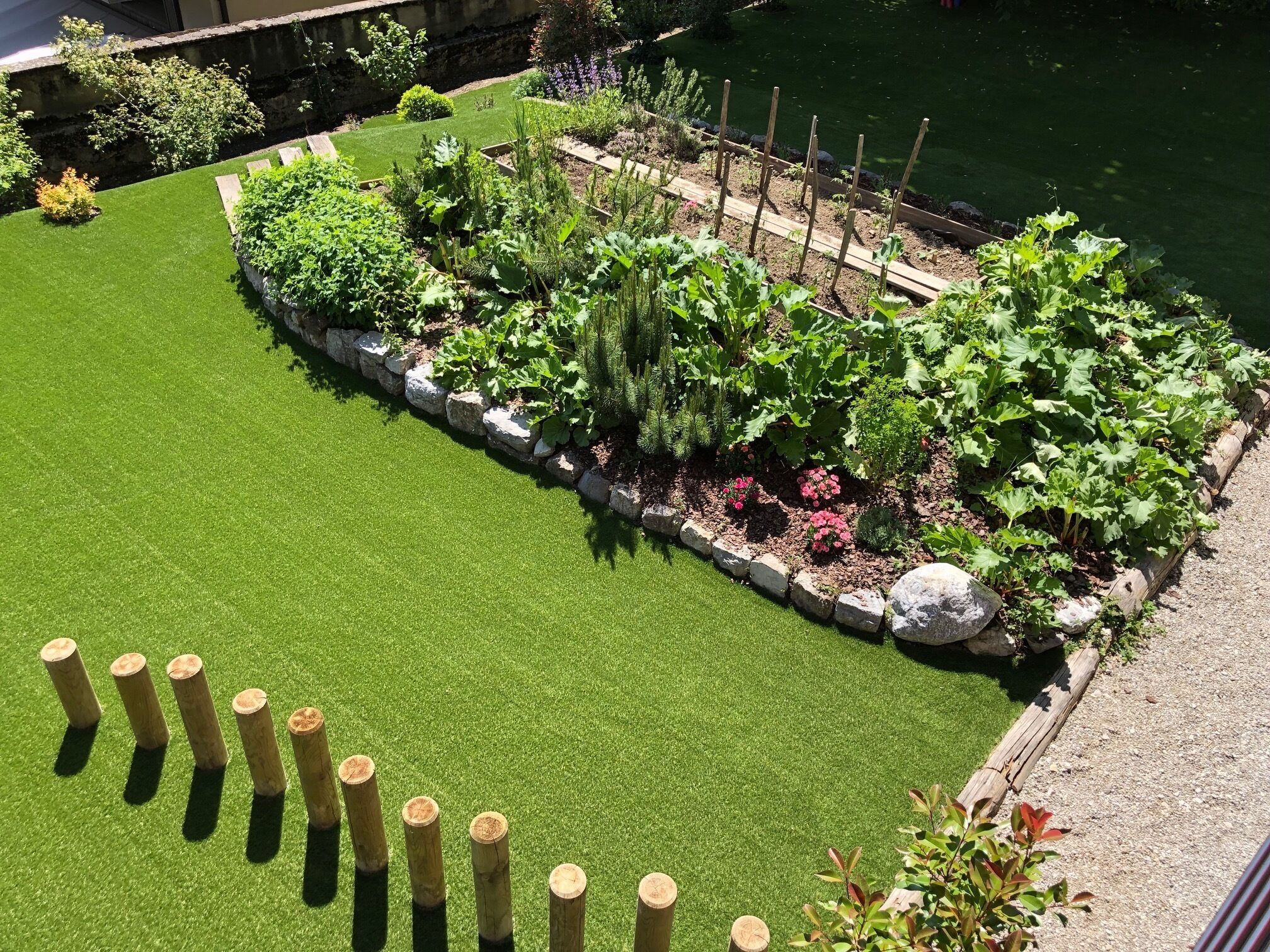 Un jardin bien entretenu, avec une grande variété de plantes et un petit étang.